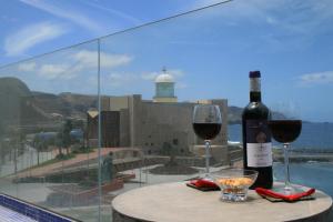 Una botella de vino y dos copas en una mesa. en Las Canteras Beach en Las Palmas de Gran Canaria