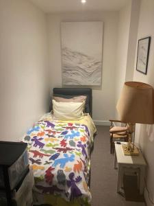 - une chambre avec un lit et une table avec une lampe dans l'établissement Sublime appartement d’architecte, à Courbevoie