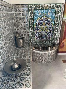 baño con lavabo y pared de mosaico en Dar Lella Hasna, en Sfax
