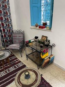 a living room with a table and a chair at Dar Lella Hasna in Sfax