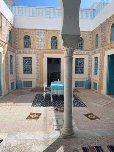 ein Zimmer mit einem Tisch in der Mitte eines Gebäudes in der Unterkunft Dar Lella Hasna in Sfax