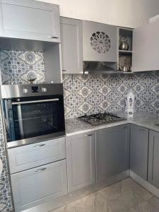a kitchen with white cabinets and a stove top oven at Dar Lella Hasna in Sfax