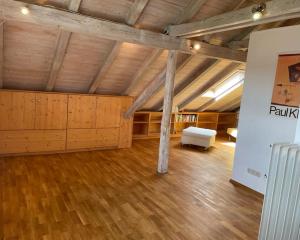 a large room with a white bed and wooden floors at Sonnige Ferienwohnung Maja in Heroldsberg