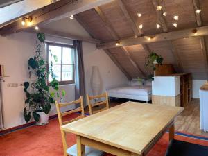 a living room with a wooden table and a bedroom at Sonnige Ferienwohnung Maja in Heroldsberg