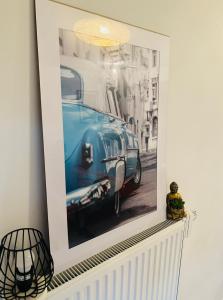 a picture of an old blue car on a wall at Élégant appartement (quartier européen) in Brussels