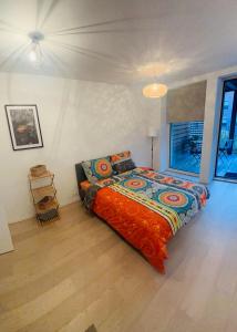 1 dormitorio con 1 cama con un edredón colorido en Élégant appartement (quartier européen) en Bruselas