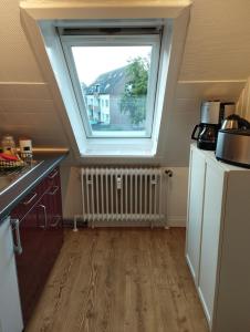 a kitchen with a large window in a attic at Apartment Wittorf in Neumünster