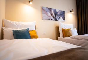 um quarto de hotel com duas camas com almofadas em Elixír Panzió em Nyírbátor