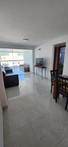 duży salon z kanapą i stołem w obiekcie Vista espectacular 180° Murano Praia do Morro w mieście Guarapari