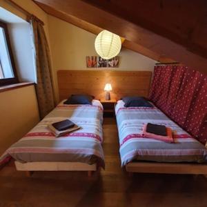 a bedroom with two beds and a chandelier at L´ouillon in Lanslebourg-Mont-Cenis