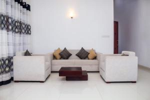 a living room with two couches and a coffee table at Villa Double T Residence in Ambalangoda
