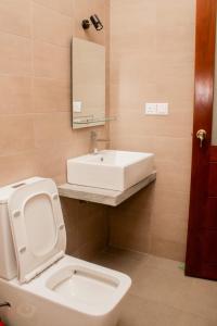 a bathroom with a white toilet and a sink at Villa Double T Residence in Ambalangoda