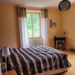 1 dormitorio con cama, ventana y mesa en Domaine de la Charrière sur 63 ares - 8 pers grand confort en Neuviller