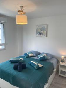 Un dormitorio con una cama grande con almohadas azules. en Villa des Cerisiers, en Saint-Nazaire