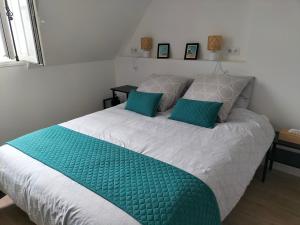 a bedroom with a large bed with blue pillows at MUTUM - Studios 2 personnes, idéalement placés à 100m de la plage in Dieppe