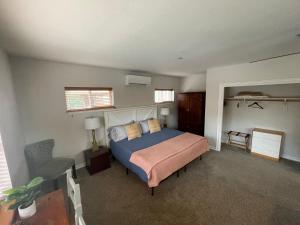 1 dormitorio con 1 cama y 1 silla en Goldsmith's River Front Inn, en Missoula