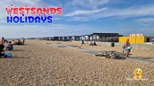 a group of people on a beach with buildings at 3 Bedroom Caravan at Seal Bay Resort in Selsey