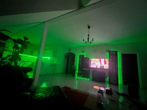 a dark room with green lights on the walls and a room with a unintention at Gabe's Nest in Üröm