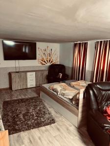 a room with a bed and a couch and a tv at Best Price Guesthouse in Szeged