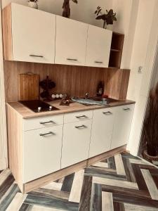 a kitchen with white cabinets and a sink at Best Price Guesthouse in Szeged
