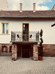 a house with a balcony on top of it at Best Price Guesthouse in Szeged