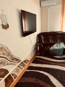 a living room with a couch and a television at Best Price Guesthouse in Szeged