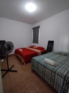 a bedroom with two beds and a fan in it at No disponible in Xilitla