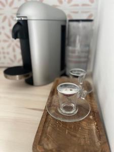 eine Kaffeetasse aus Glas auf einem Holztablett in der Unterkunft DisneylandParis Cosy indépendance in Chalifert