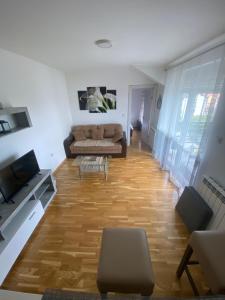 - un salon avec un canapé et du parquet dans l'établissement Apartman Una, à Čačak