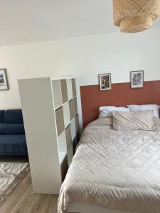 ein Schlafzimmer mit einem Bett und einer blauen Couch in der Unterkunft DisneylandParis Cosy indépendance in Chalifert + 4 Fotos