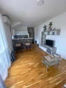 Il comprend un salon doté de parquet et d'une table. dans l'établissement Apartman Una, à Čačak