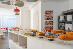 リミニにあるHotel Villa Marinaのビュッフェ式のケーキやパイ各種を用意しています。