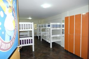 a room with rows of bunk beds and lockers at Hostel Toca da Moréia Bombinhas in Bombinhas