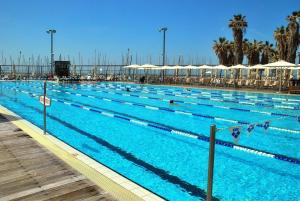 a large swimming pool with many people in it at Jaffa Family Penthouse, sea front , 3BR, 2BA, in Tel Aviv