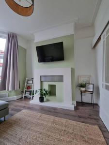 a living room with a fireplace with a tv on the wall at Home from Home Liverpool - Entire Home in Liverpool