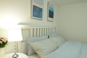 a bedroom with a bed with blue sheets and a lamp at Spacious 2-Bed-Room near Yonge & Major Mackenzie in Richmond Hill