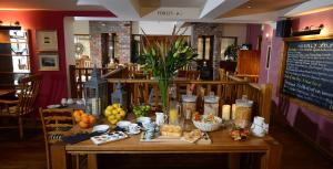 una mesa con comida y velas en un restaurante en The Birley Arms Hotel Warton en Lytham St Annes