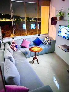 a living room with a couch and a table at The PEARL of ACHAKAR , your 5 STAR cozy apartment in Tangier