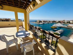 een balkon met een tafel en stoelen en uitzicht op het water bij شقق تالابيه talabay apartment swimming pools and sea view Aqaba in Aqaba