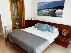 Casa en la playa con piscina في كوبيليس: غرفة نوم مع سرير وحمام مع رصيف