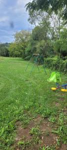 a green swing set in a field of grass at Vajat Vasiljević in Mladenovac