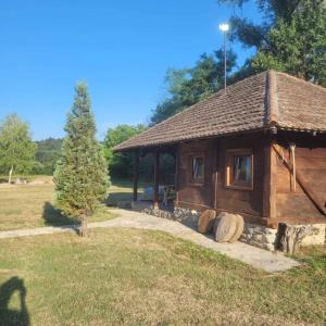 a log cabin in a park with a tree at Vajat Vasiljević in Mladenovac