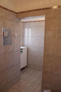 a bathroom with a shower and a tiled floor at Morgado Guest House in Ervedal