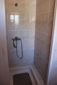 a bathroom with a shower with a tiled wall at Morgado Guest House in Ervedal