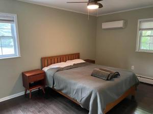 a bedroom with a bed and a table and a fan at Cute ranch house, less than 1 mile to downtown and skidmore. 2 miles to the track and SPAC in Saratoga Springs