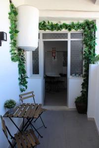 een patio met 2 stoelen en een tafel en een kamer bij Morgado Guest House in Ervedal