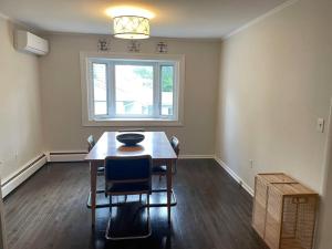 a dining room with a table and chairs and a window at Cute ranch house, less than 1 mile to downtown and skidmore. 2 miles to the track and SPAC in Saratoga Springs