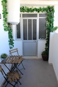 a patio with two chairs and a table and plants at Morgado Guest House in Ervedal