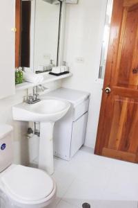 y baño con lavabo, aseo y espejo. en Apartamento - Resort Bunsichari, en Santa Marta