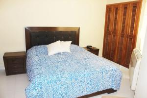 1 dormitorio con 1 cama con edredón azul en Apartamento - Resort Bunsichari, en Santa Marta